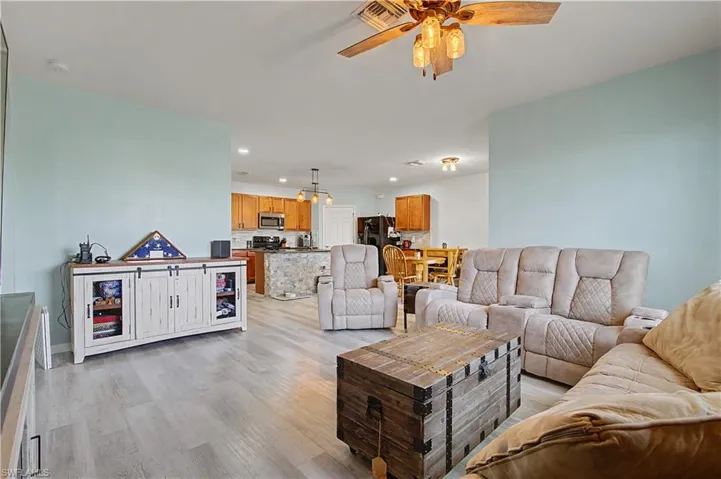 Living area featuring light wood-type flooring, ceiling fan, and recessed lighting