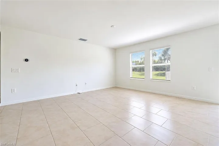 Neutral-toned tile flooring, dual windows with exterior scenery, and smooth-finish walls