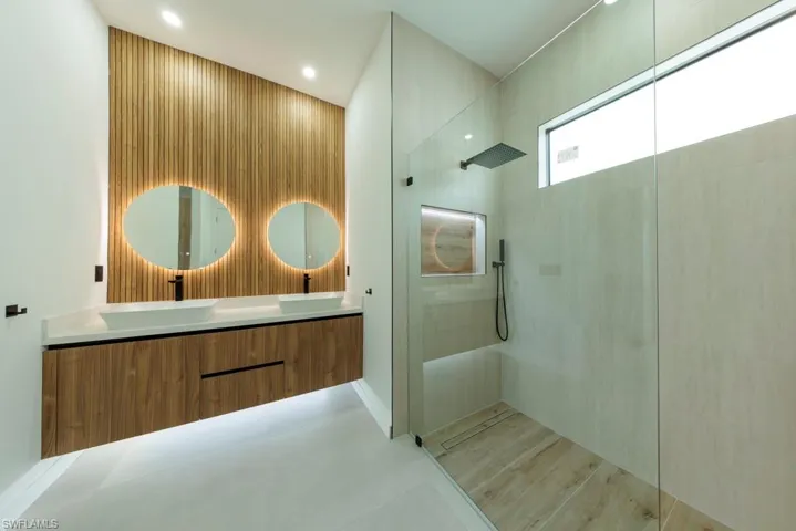 Bathroom featuring walk in shower and double vanity
