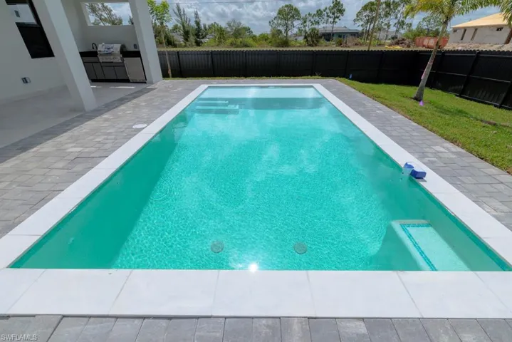 View of pool featuring area for grilling, a fenced backyard, and a patio