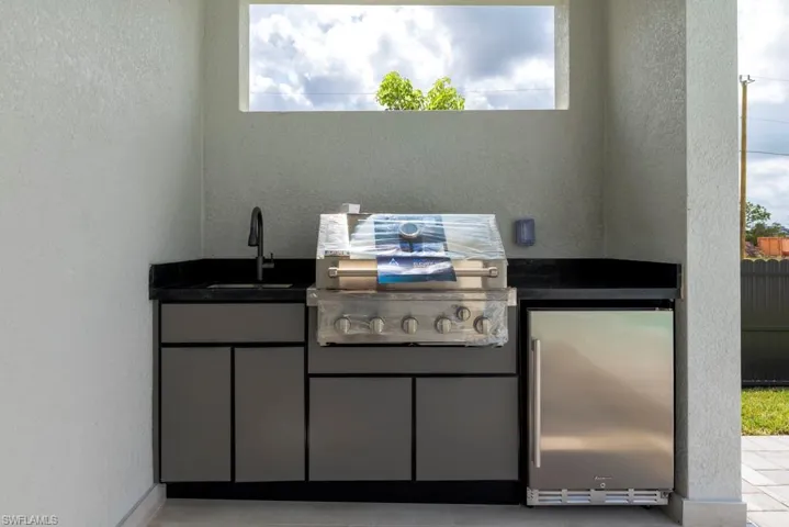 View of patio / terrace featuring a grill and a sink