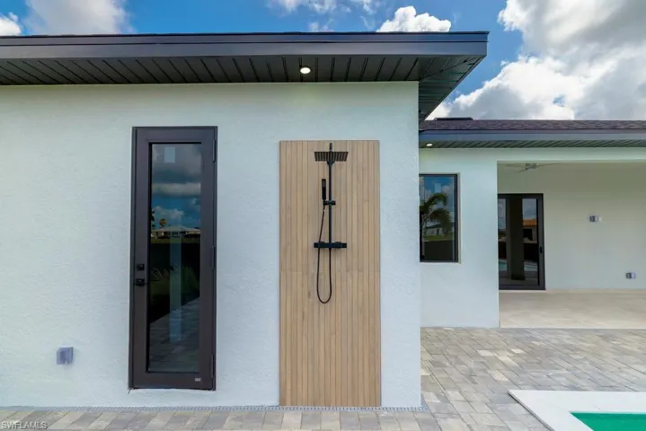 Property entrance with stucco siding and a patio area