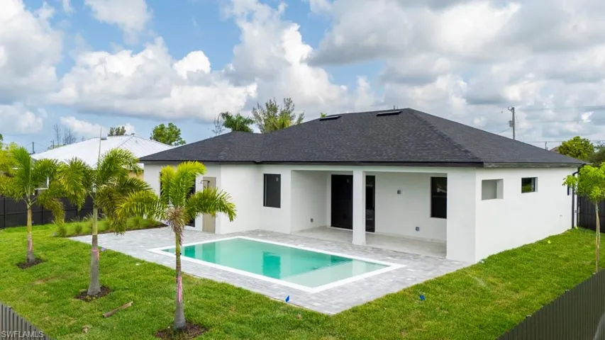 Back of house with a patio area, a shingled roof, and stucco siding