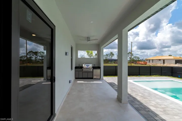 View of pool with area for grilling, a fenced backyard, ceiling fan, and a patio area