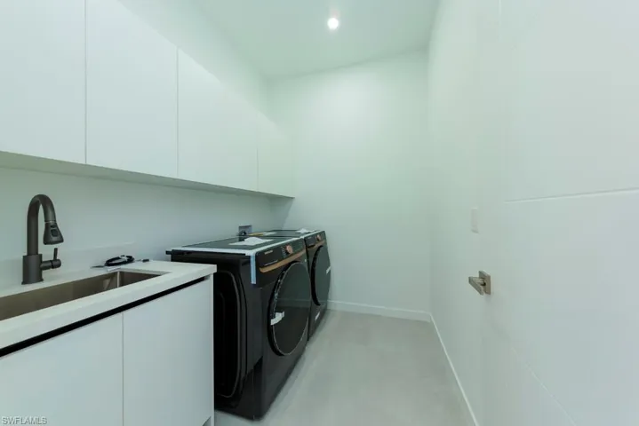Laundry room featuring cabinet space, washing machine and dryer, and recessed lighting