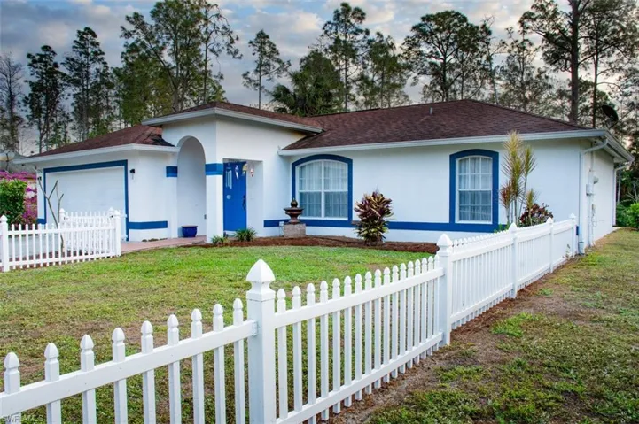 Single story home with a garage and a front lawn