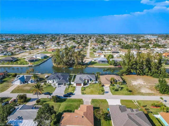 Aerial view of property and surrounding area with a large body of water and nearby suburban area