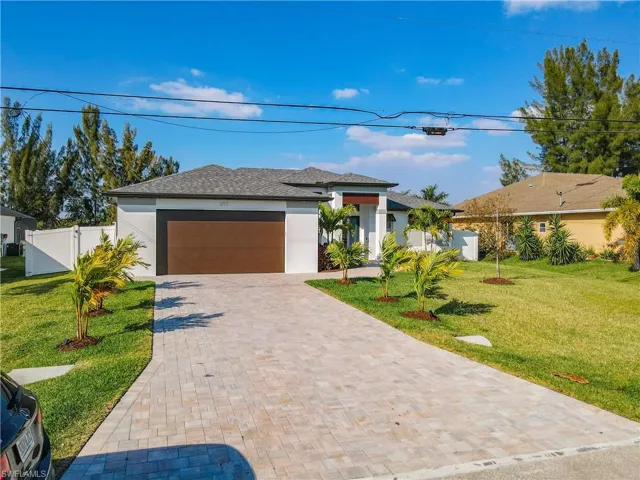 Prairie-style home featuring stucco siding, decorative driveway, a garage, and roof with shingles