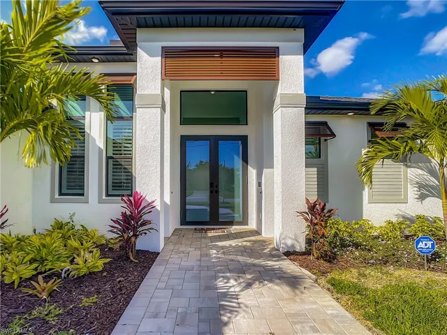 Property entrance with stucco siding and french doors
