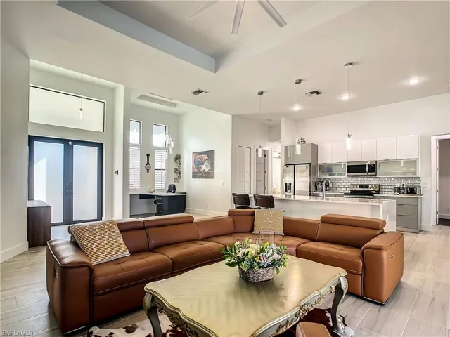 Living room featuring light wood-type flooring, a ceiling fan, and french doors