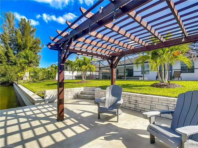 View of patio with a pergola and a water view