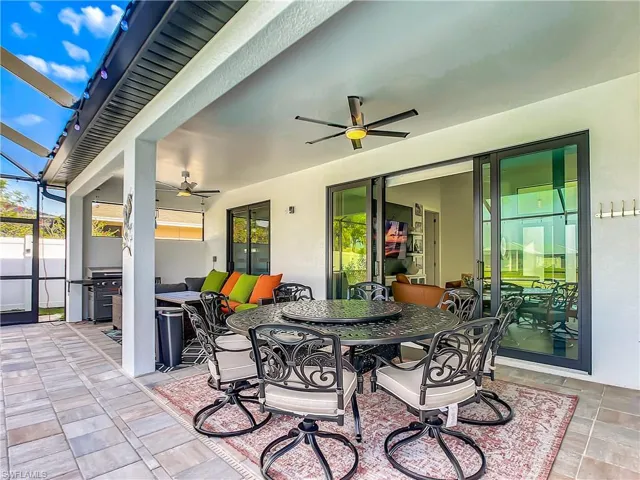 View of patio featuring outdoor dining space, a sunroom, area for grilling, and glass enclosure