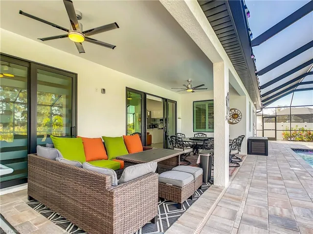 View of patio / terrace featuring a sunroom, outdoor dining area, ceiling fan, and an outdoor living space