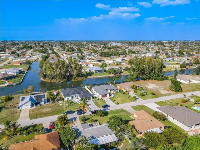 Aerial overview of property's location featuring a nearby body of water and nearby suburban area