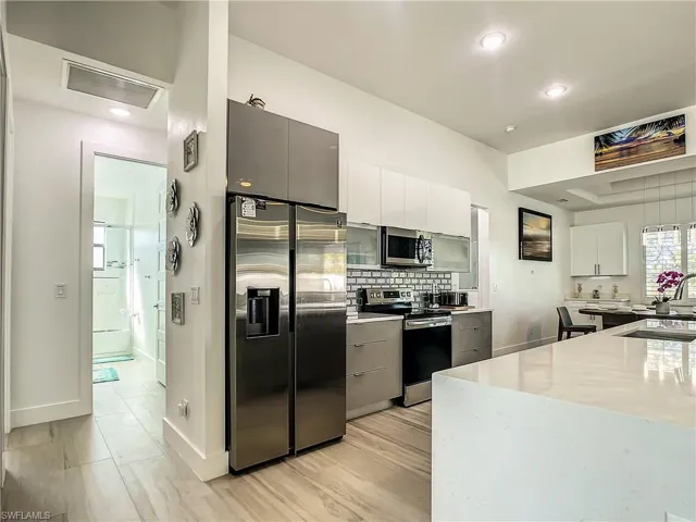 Kitchen with white cabinetry, appliances with stainless steel finishes, modern cabinets, backsplash, and recessed lighting