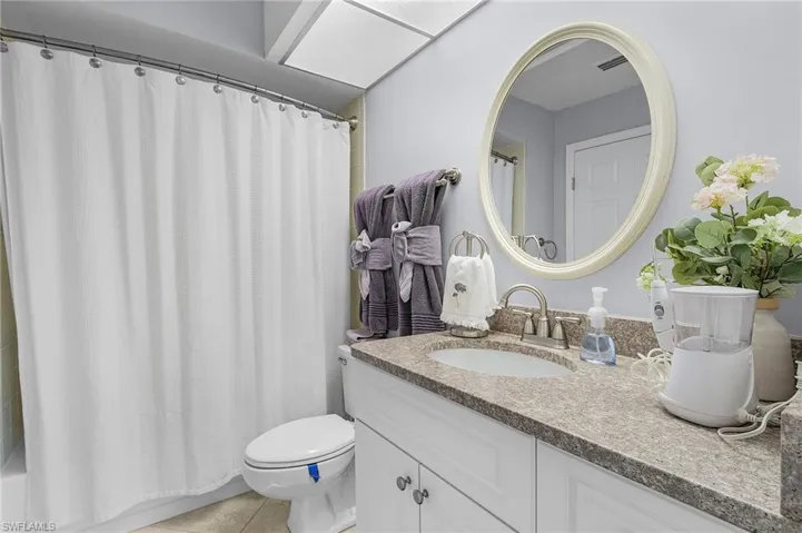 Second bathroom with tile patterned floors, walk-in shower, toilet, and vanity