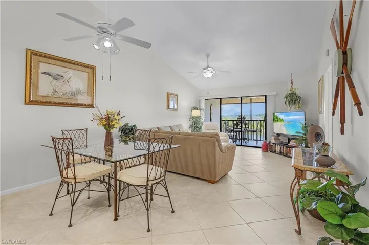 Tiled dining space featuring ceiling fan and vaulted ceiling