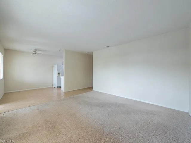 Carpeted empty room with ceiling fan