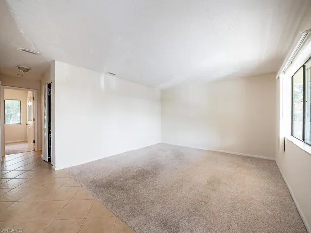 Unfurnished room with light carpet and a textured ceiling