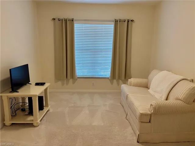 Living area with light colored carpet and plenty of natural light