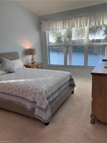 Bedroom with carpet floors and a water view