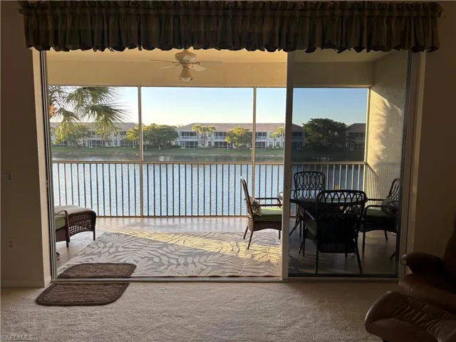 Sunroom with ceiling fan and a water view