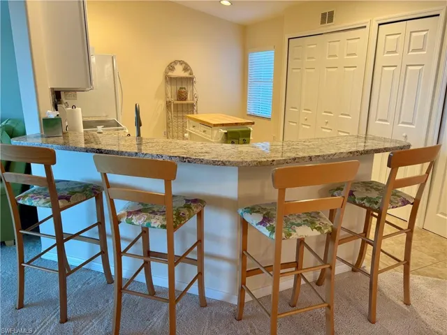 Kitchen with kitchen peninsula and light colored carpet