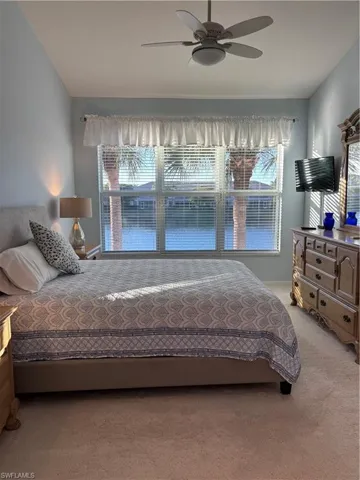 Bedroom with ceiling fan and light carpet