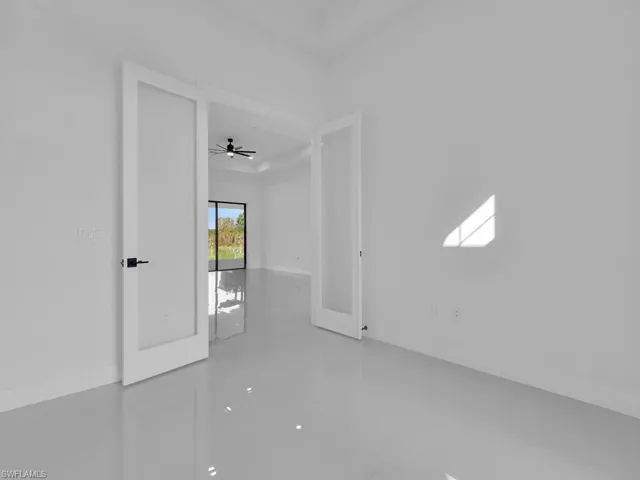 Empty room with ceiling fan and french doors