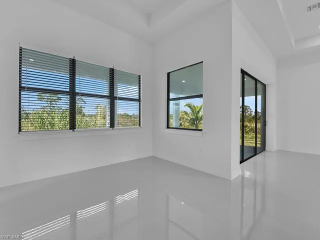 Tiled empty room with a raised ceiling and plenty of natural light