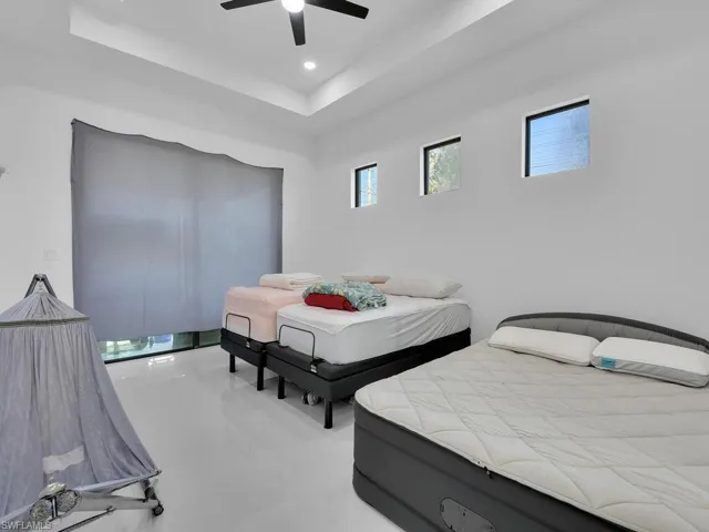 Bedroom with ceiling fan and a tray ceiling