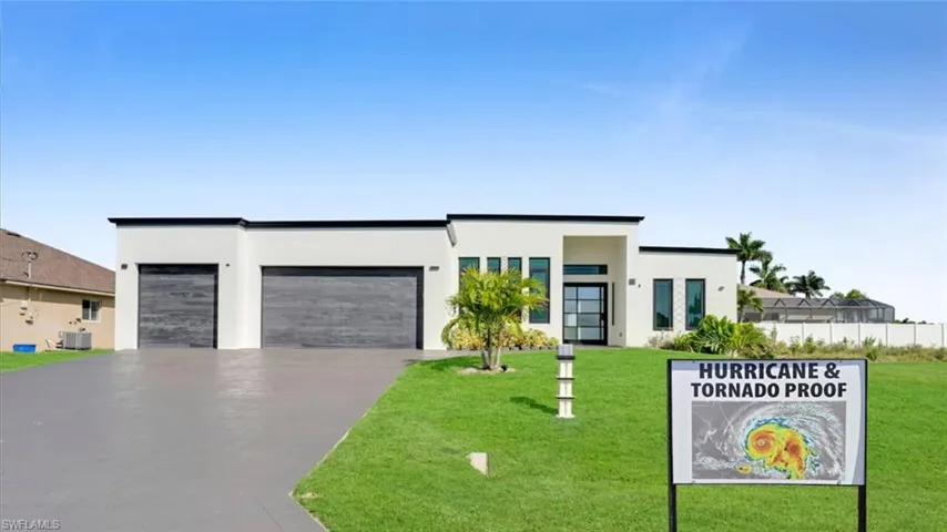 Contemporary home featuring a garage, driveway, and stucco siding