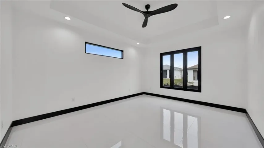 Unfurnished room featuring recessed lighting, tile patterned floors, ceiling fan, and a tray ceiling