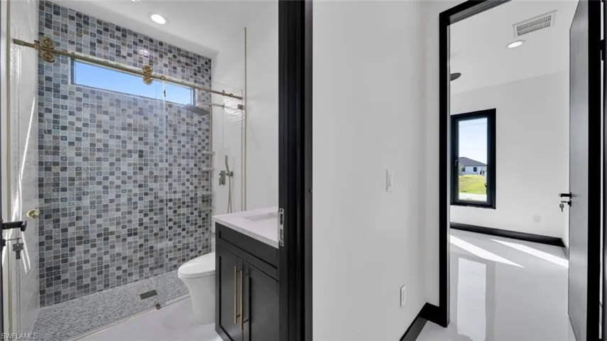 Full bathroom featuring vanity, a stall shower, and recessed lighting