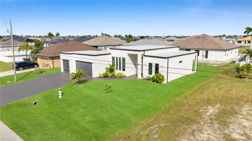 View of front of property featuring a garage, a residential view, stucco siding, and asphalt driveway