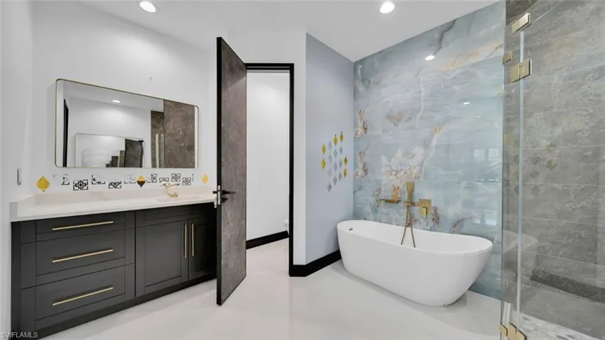 Bathroom featuring vanity, a freestanding tub, and recessed lighting