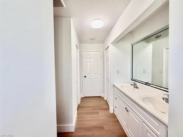 Bathroom with hardwood / wood-style flooring, a textured ceiling, and vanity