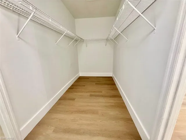 Spacious closet with hardwood / wood-style floors