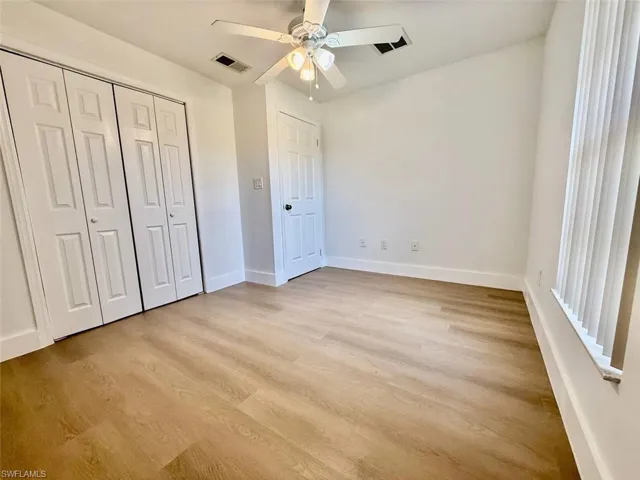 Unfurnished bedroom with ceiling fan, light hardwood / wood-style flooring, and a closet