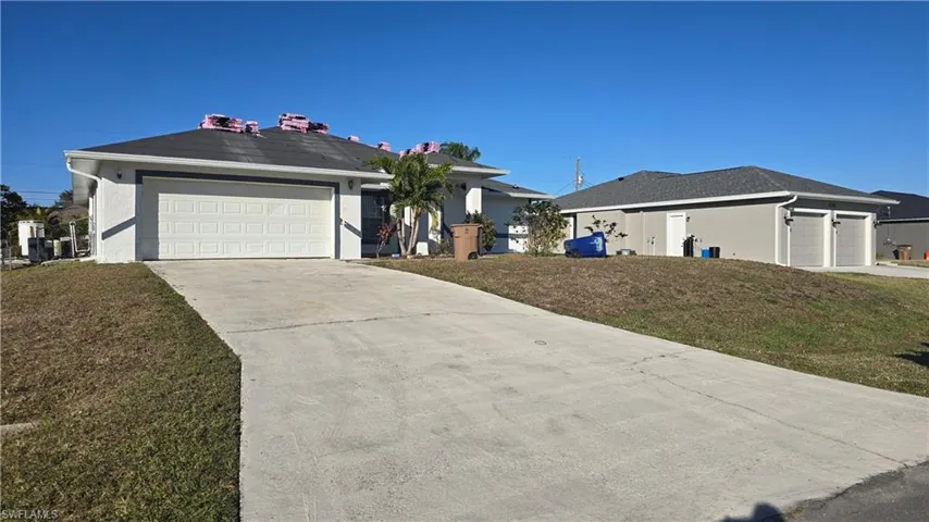 Ranch-style house featuring a garage and a front yard