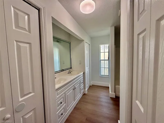 Bathroom featuring a textured ceiling, wood-type flooring, and vanity