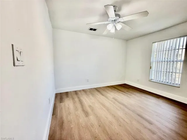 Empty room with ceiling fan and light hardwood / wood-style floors