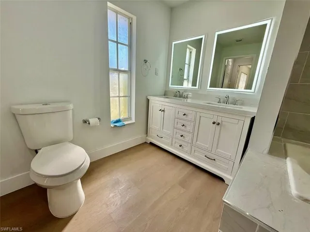 Bathroom featuring wood-type flooring, toilet, and vanity