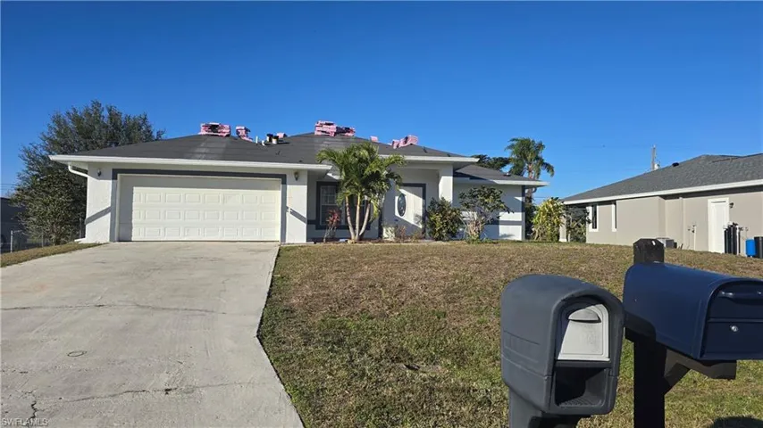 Ranch-style home with a garage and a front lawn