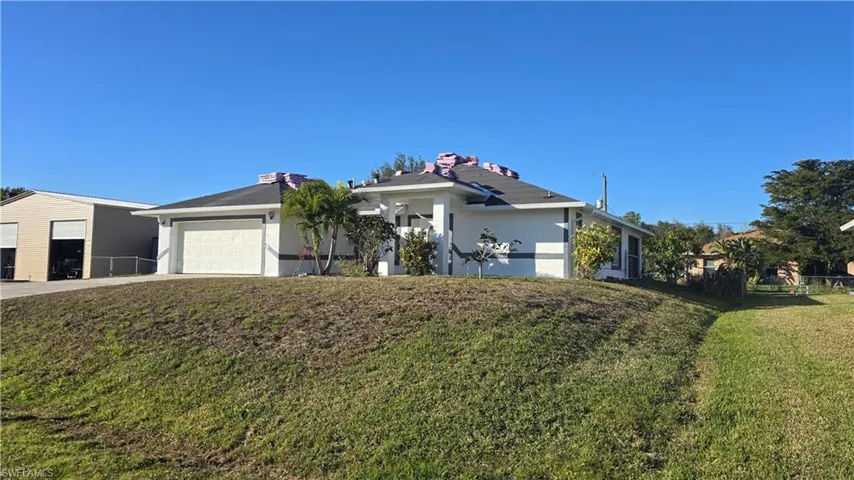 Ranch-style home with a garage and a front lawn