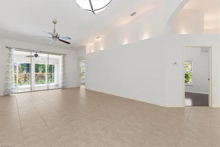 Tiled spare room with high vaulted ceiling, ceiling fan, and plenty of natural light
