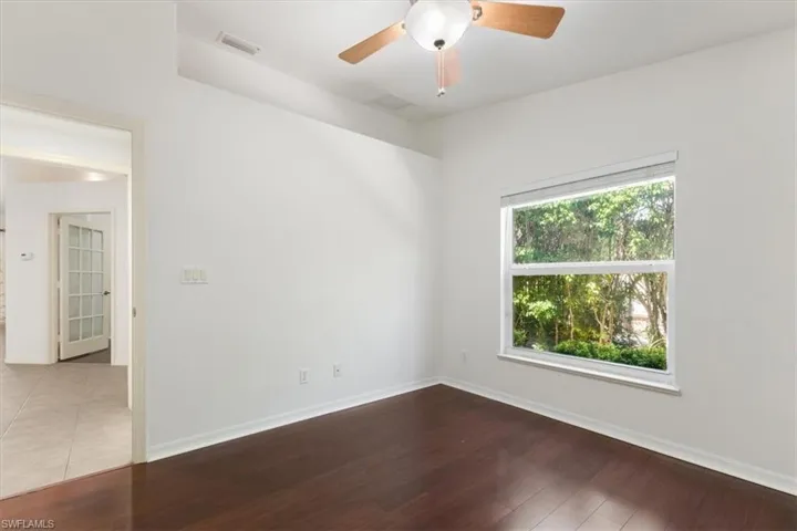 Empty room with hardwood / wood-style floors and ceiling fan
