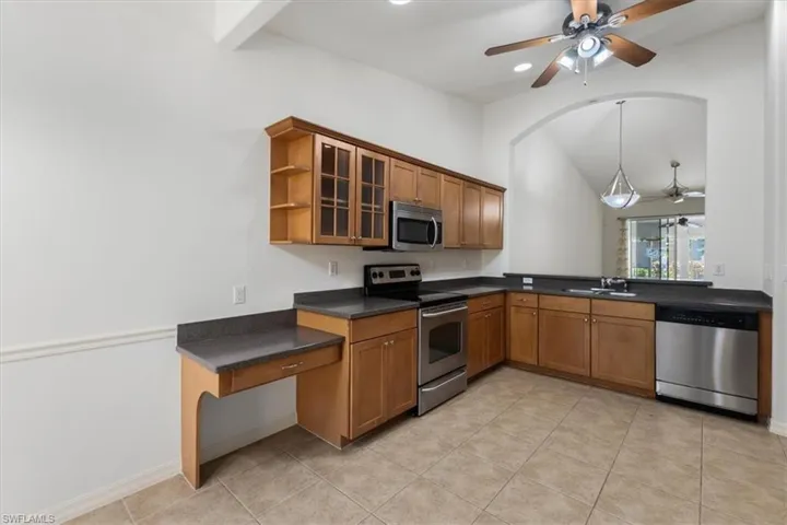 Kitchen featuring ceiling fan, light tile patterned flooring, appliances with stainless steel finishes, and hanging light fixtures