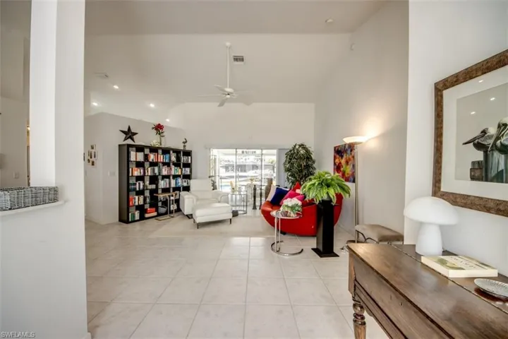 Living area featuring ceiling fan, light tile patterned flooring, recessed lighting, and lofted ceiling