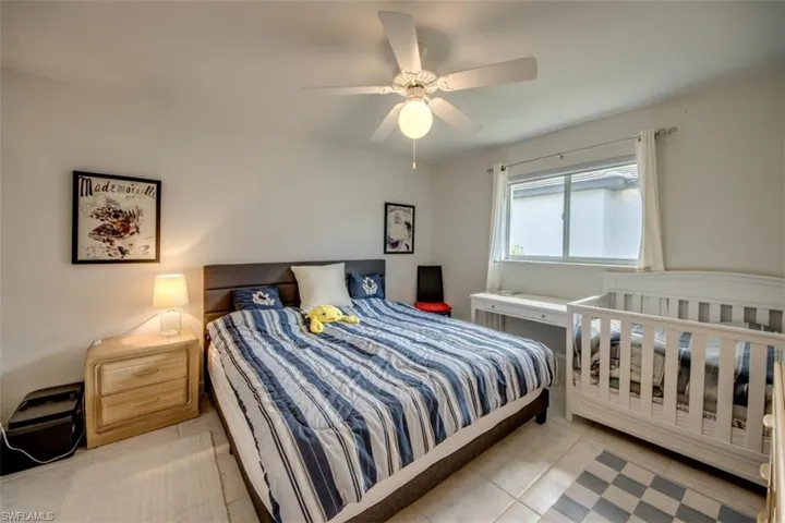 Bedroom with light tile patterned floors and ceiling fan